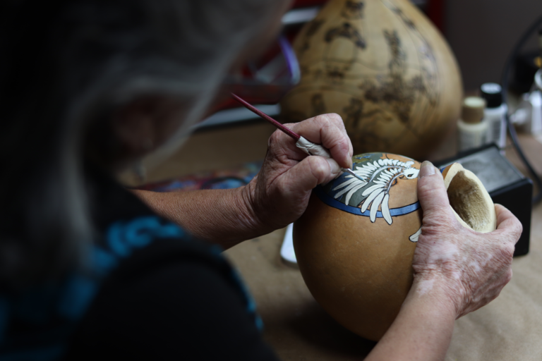 Janine painting on a gourd 1 768x512